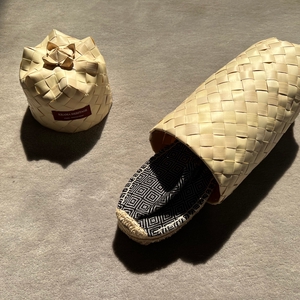 Les espadrilles Diamond Noir Ebène dans leur grand écrin naturel en feuille de palmier